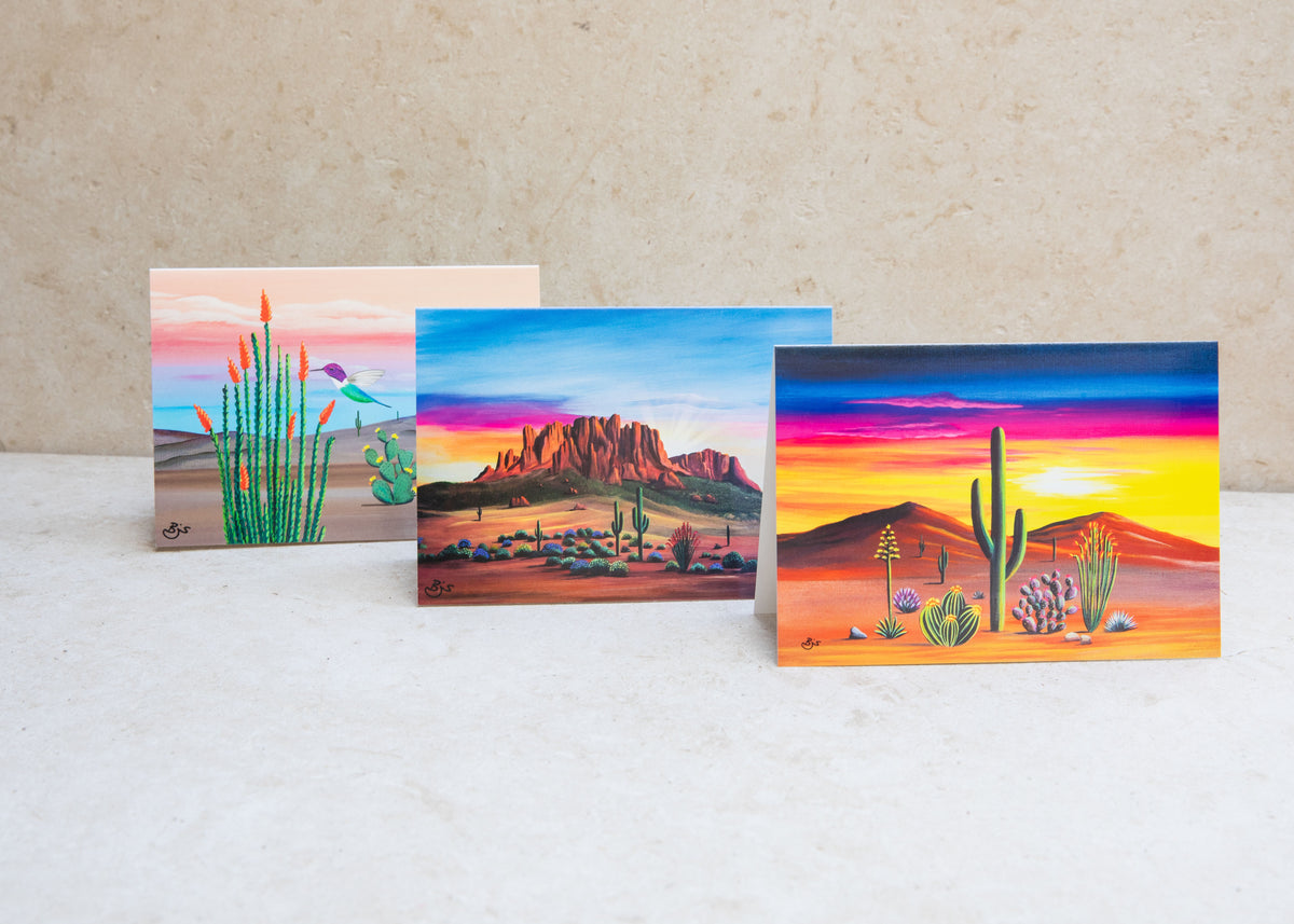 Three Arizona greeting cards by Brenda standing open: Hummingbird, Arizona Sunrise, and Sunset in Bloom