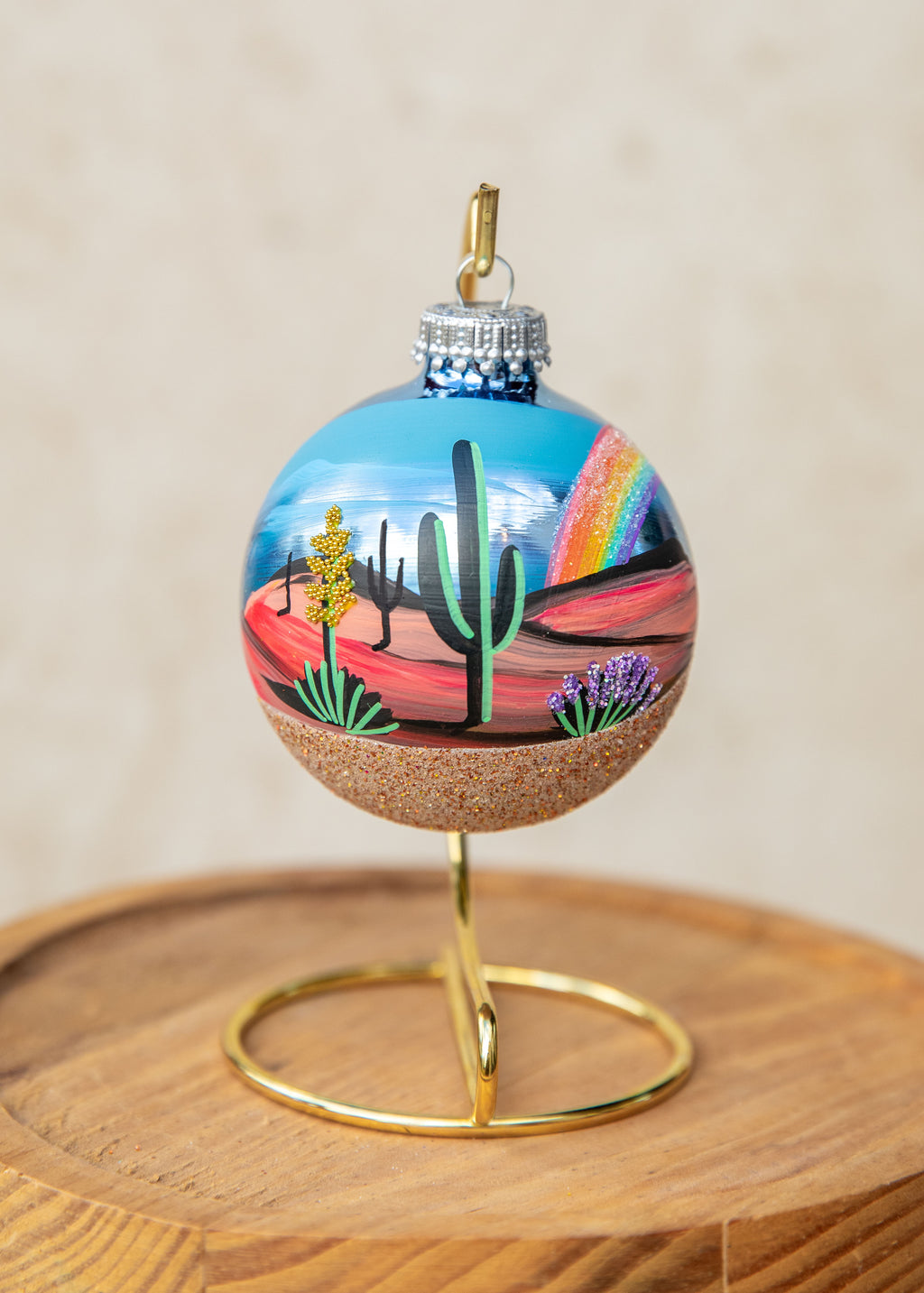 After the Storm Hand Painted glass ornament by Brenda, a saguaro in the center with a soft rainbow on the right
