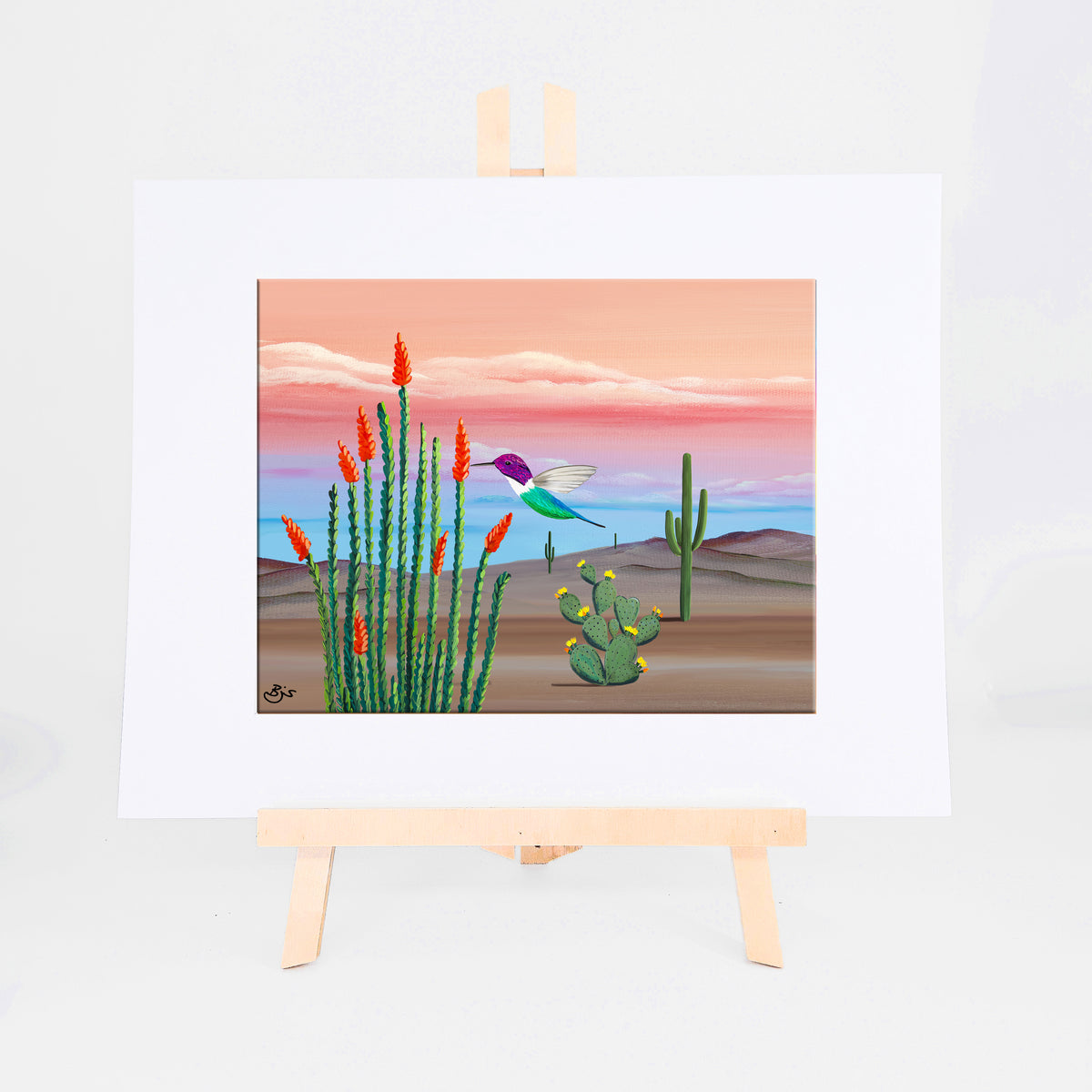 Hummingbird, Brenda's painting of a hummingbird among blooming ocotillo, prickly pear, and saguaros under a pink and blue sky, shown as a matted 8x10 art print