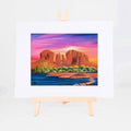 Cathedral Rock, Brenda's painting of Sedona's Cathedral Rock above desert greenery and blue water under a pink and purple sky, shown as a matted 8x10 art print